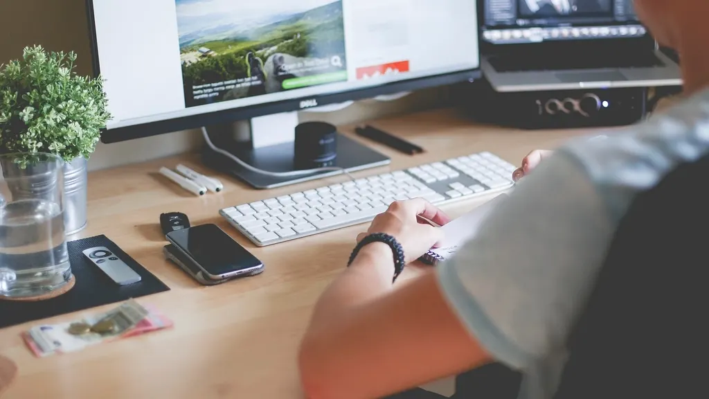Person working at a desk with a desktop monitor and keyboard