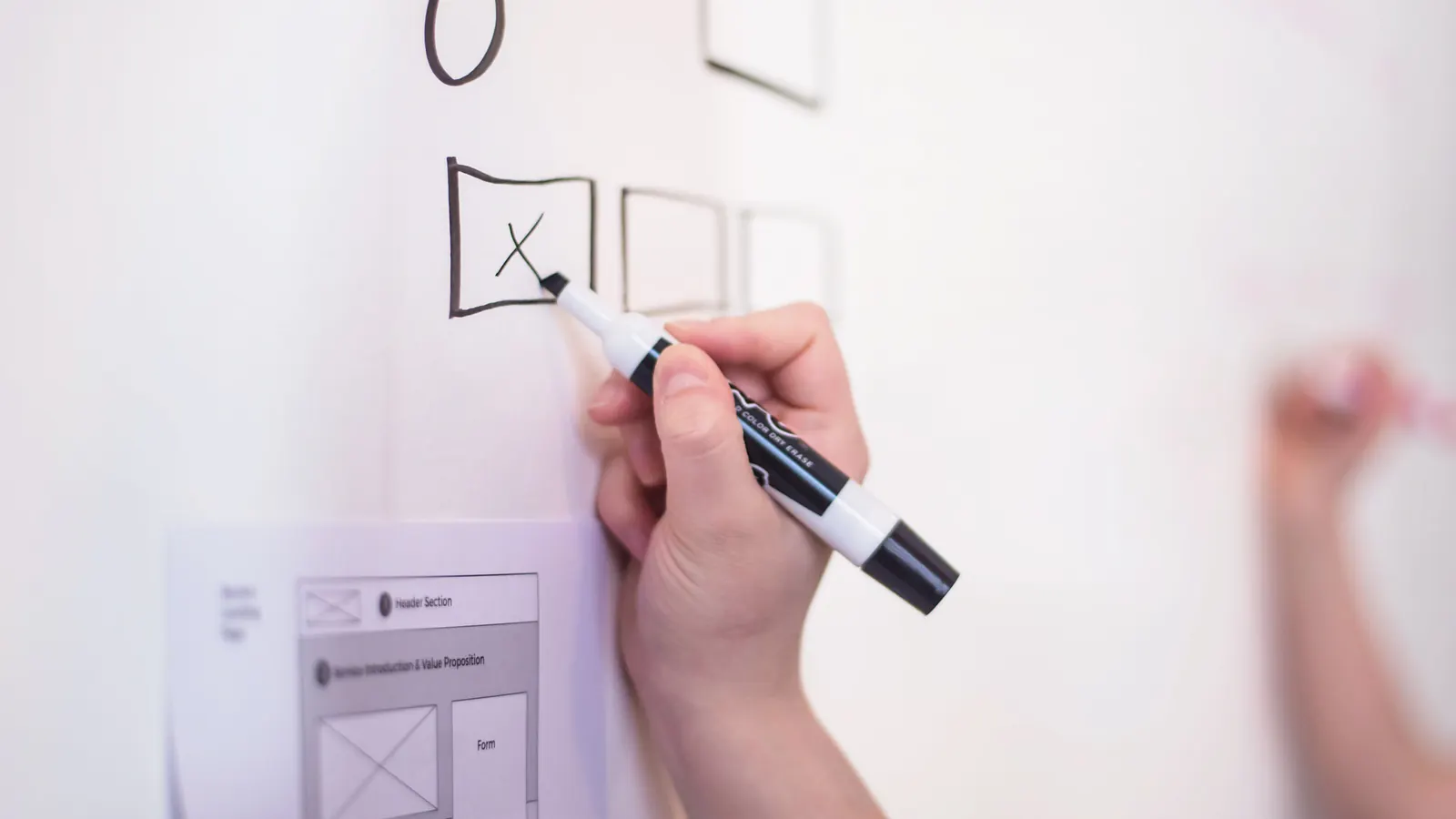 Hand drawing a checkbox on a whiteboard