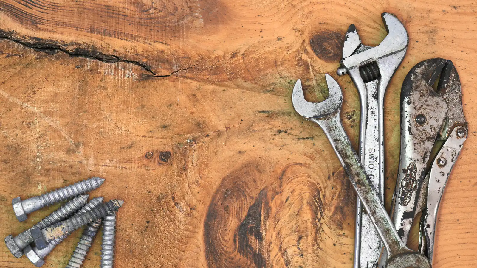 Wrenches and bolts on a wooden table